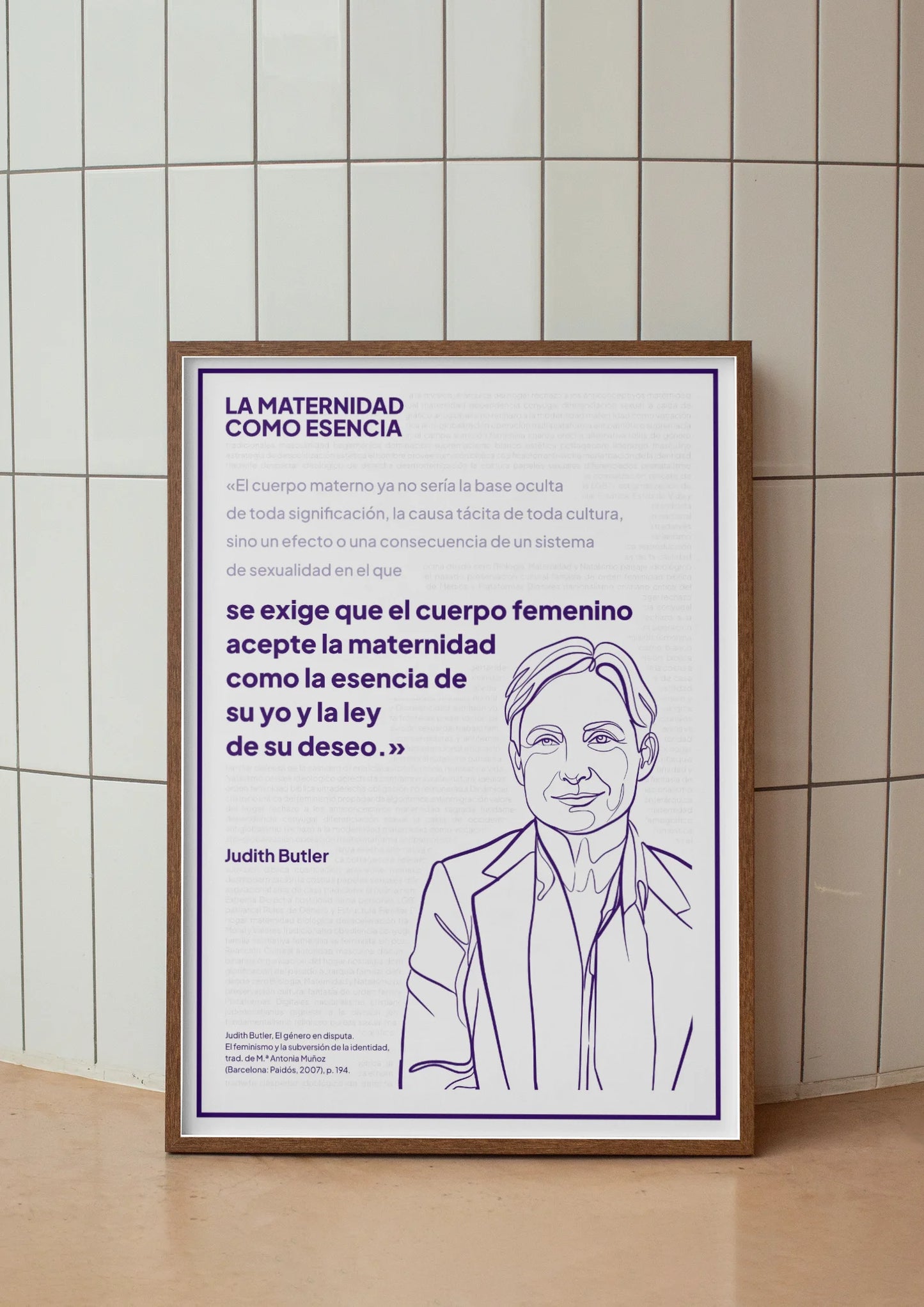 Afiche violeta de Judith Butler enmarcado frente a un muro de azulejos claros.