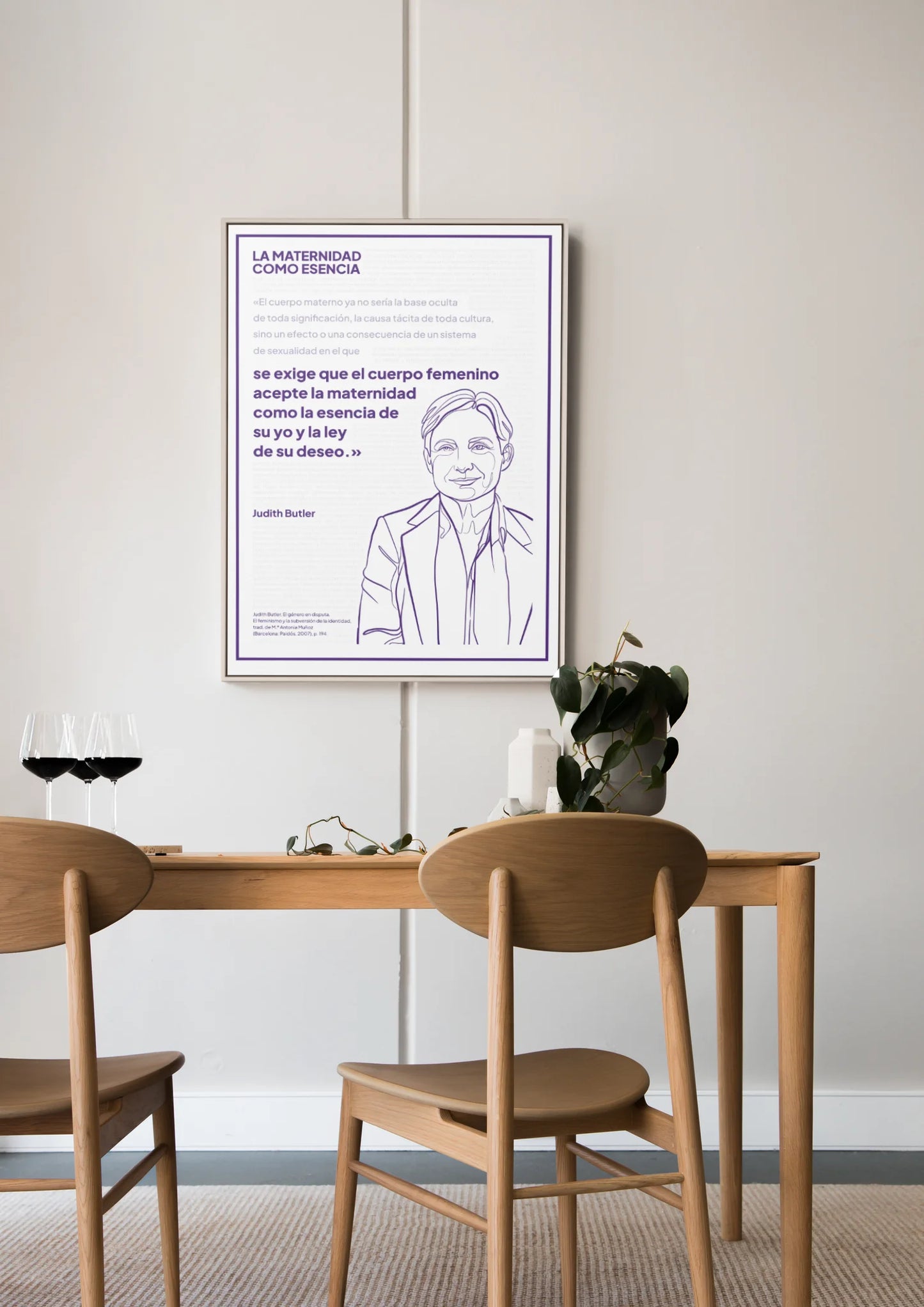 Afiche violeta de Judith Butler enmarcado sobre una mesa de comedor de madera.