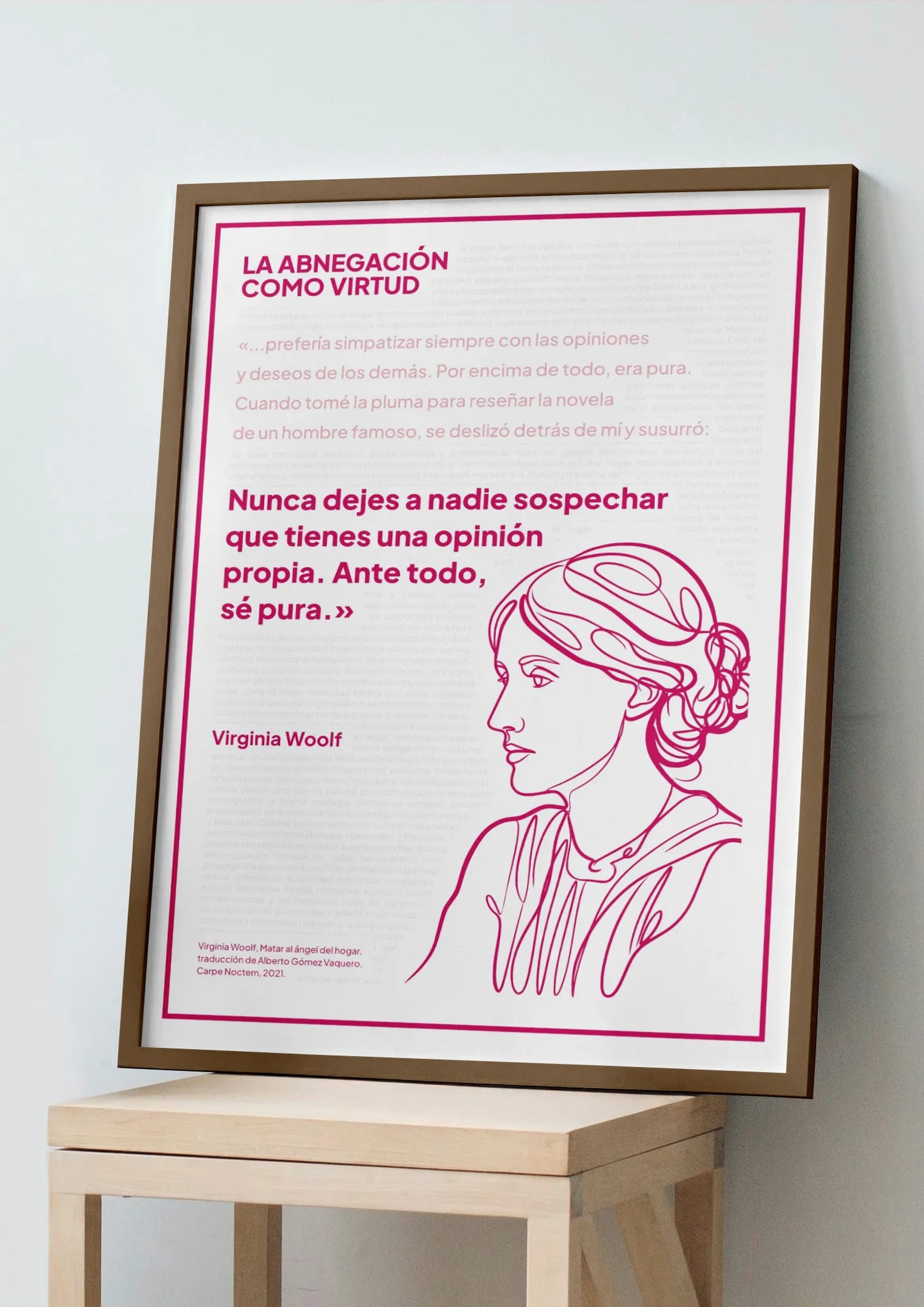 Afiche magenta de Virginia Woolf enmarcado, apoyado sobre un banco de madera clara.