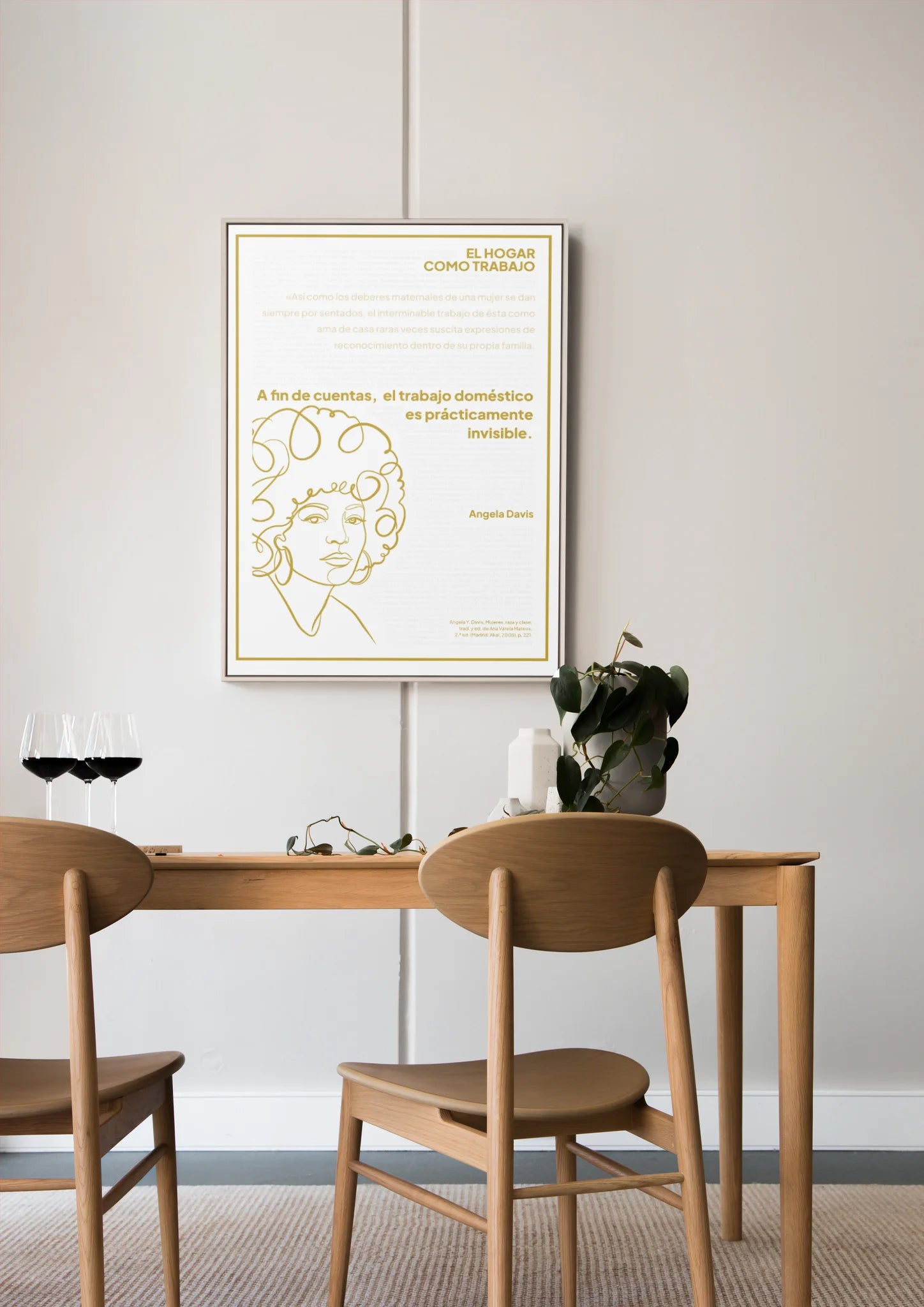 Afiche dorado de Angela Davis enmarcado sobre una mesa de comedor de madera.