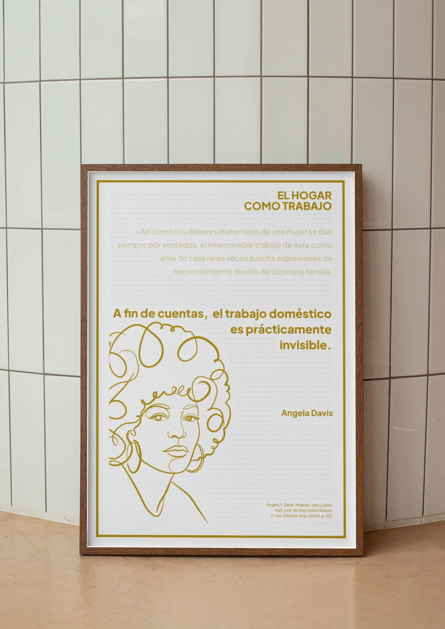Afiche dorado de Angela Davis enmarcado frente a un muro de azulejos claros.